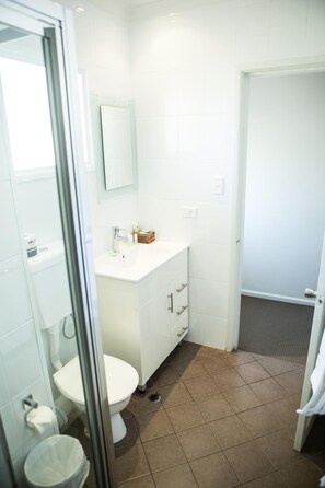 Bathroom features a toilet, sink, and shower enclosure.