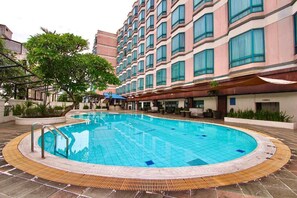 A swimming pool surrounded by a building with multiple windows and balconies.
