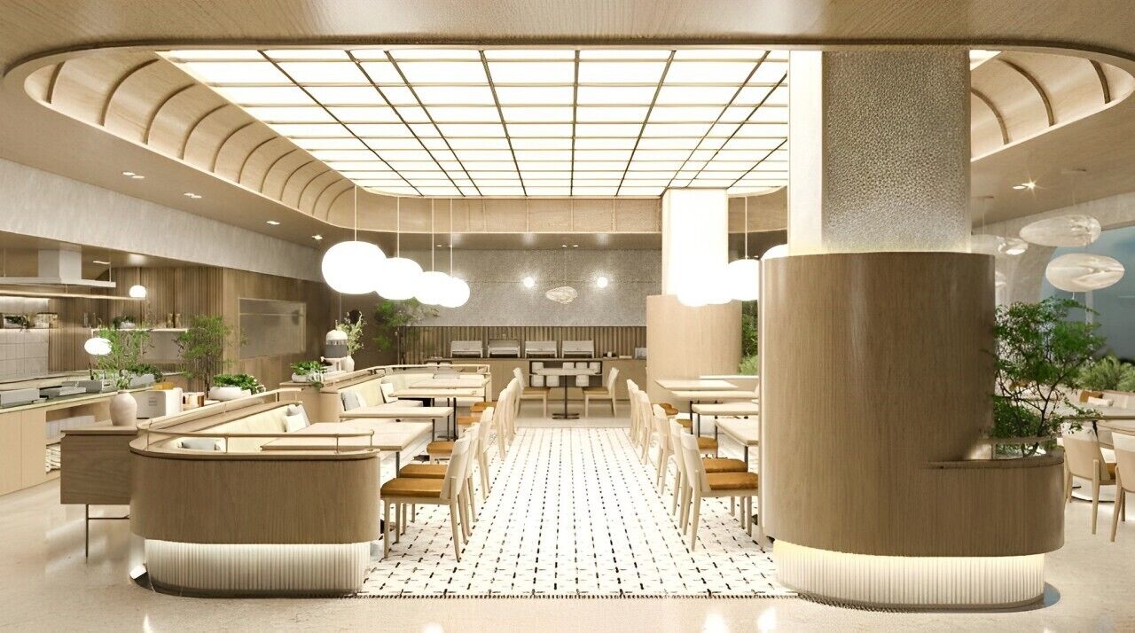Un intérieur de restaurant moderne avec un espace de restauration central, un plafond haut orné d’un motif en réseau et de grandes colonnes cylindriques.