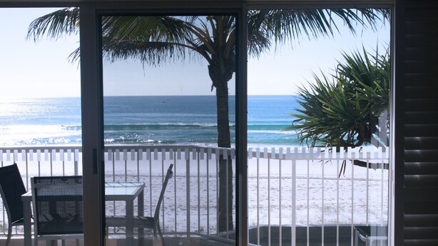 A balcony with a view of the beach, a table, chairs, and a palm tree. - Surfers Horizons Resort (Palm Beach)