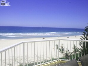 Un balcon avec vue sur une plage et l’océan.