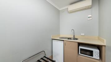 A compact kitchenette with a built-in microwave, a small refrigerator, and a sink.