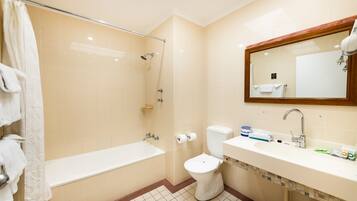 A bathroom with a bathtub, toilet, sink, and a mirror.