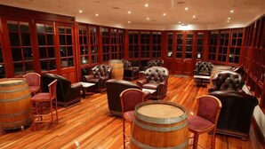 A room with wooden flooring, leather armchairs, and wooden barrels. - Tinaroo Lake Resort (Tinaroo)