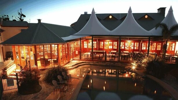 A hotel with a pool, outdoor seating, and a covered dining area. - Tinaroo Lake Resort (Tinaroo)