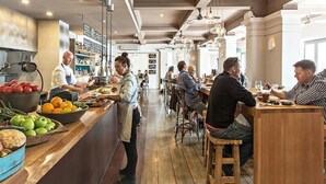 A restaurant with a long counter, bar area, and multiple tables. - Cottesloe Beach Hotel (Cottesloe)