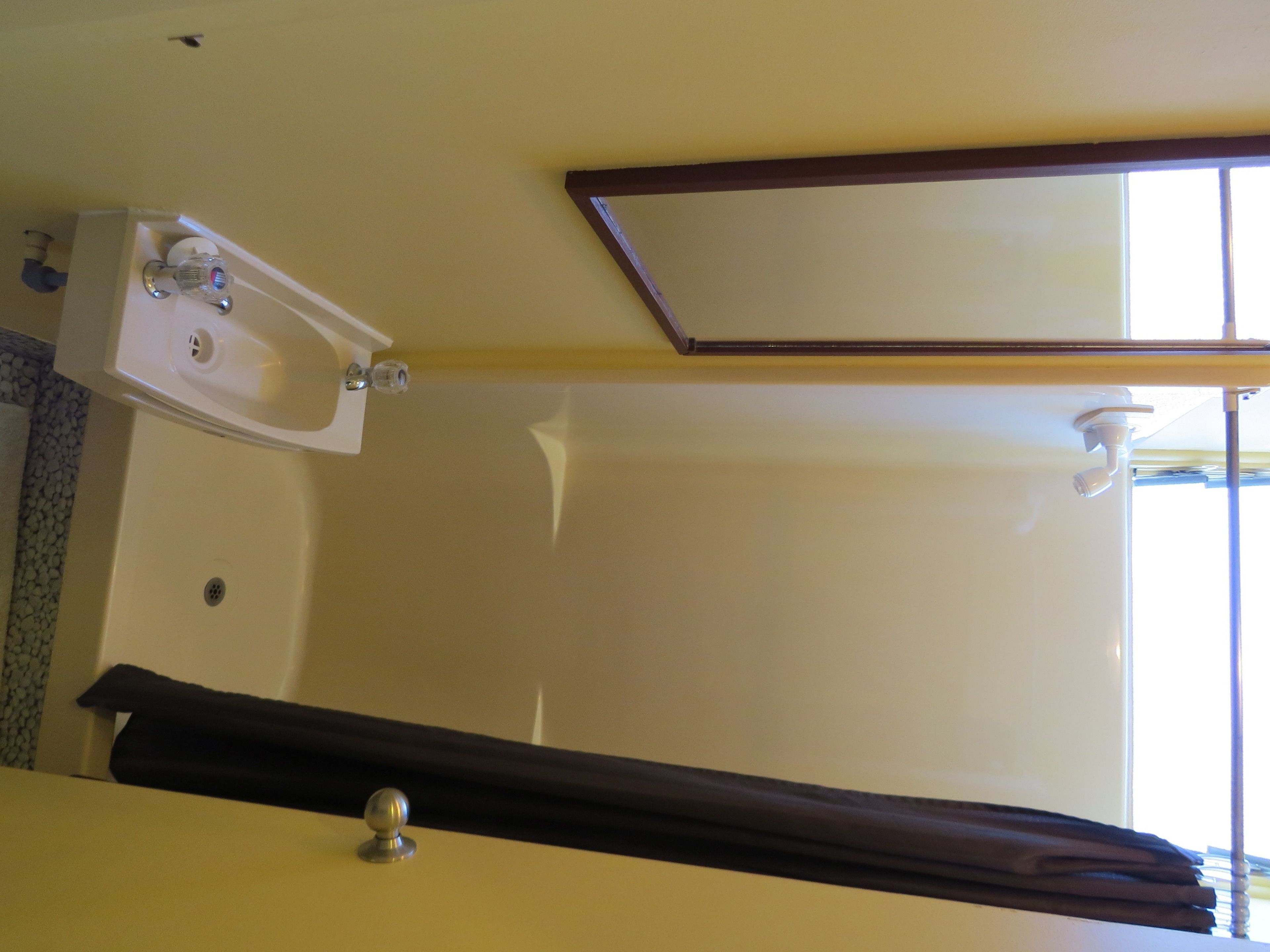 Ein Badezimmer mit Waschbecken, Spiegel und Fenster.