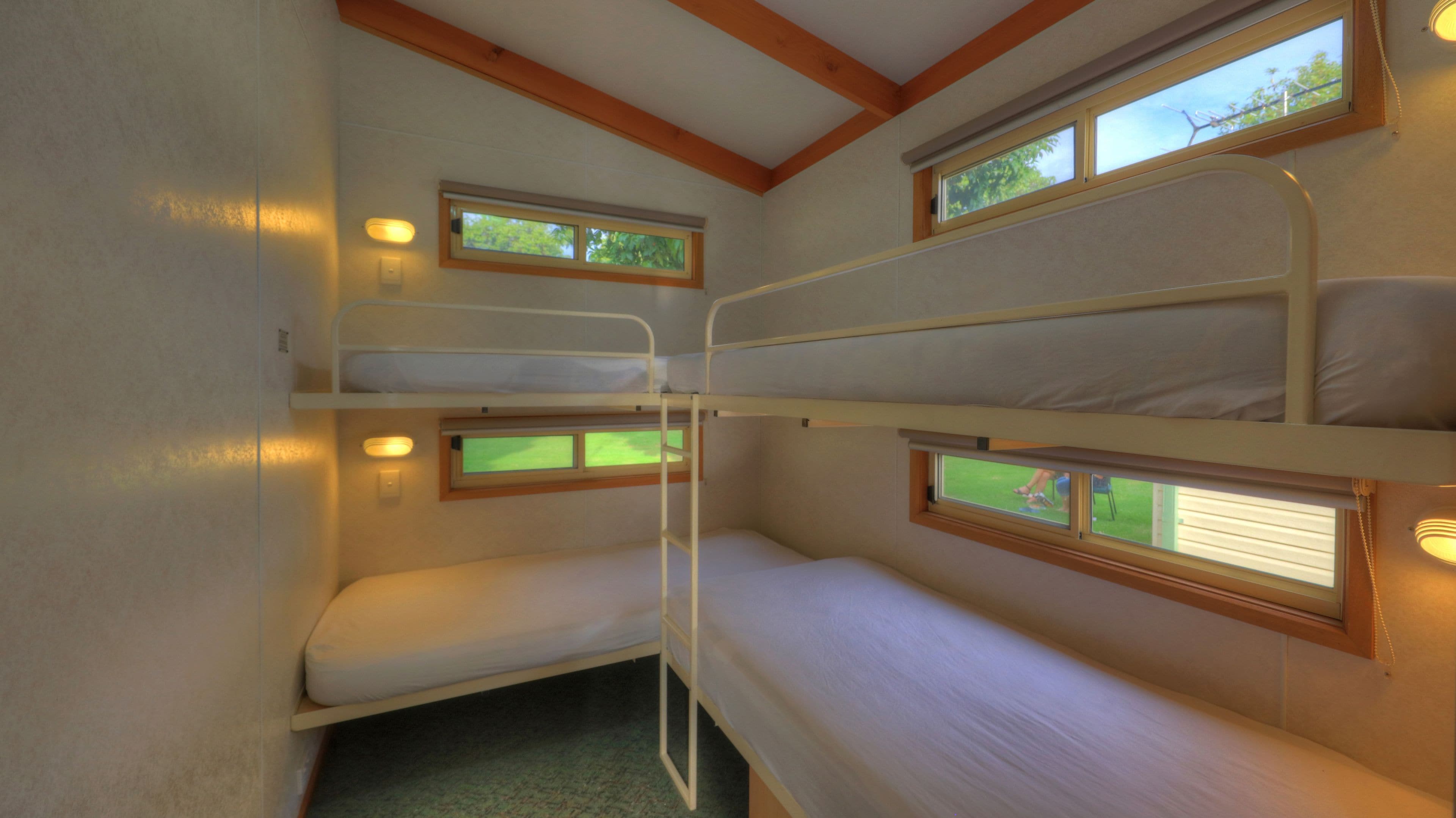 Habitación con literas y dos ventanas, cada una con vistas al exterior.