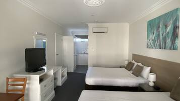 A hotel room with a bed, a TV, a desk, and a chair.