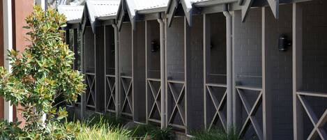 A row of rooms with a brick exterior and metal cross-bracing.