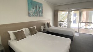 A hotel room with two beds, a painting on the wall, and a balcony with a view. - Campaspe Lodge Echuca (Echuca)