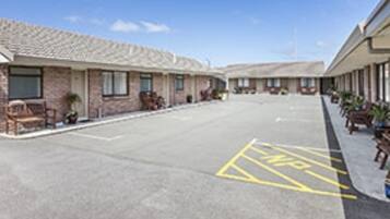 A motel with a parking lot marked with a handicap parking symbol.