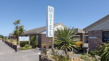 A motel with a 'No Vacancy' sign, a reception area, and a parking lot.