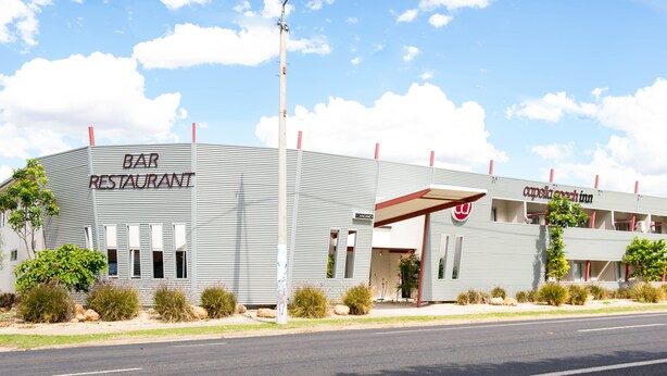 A bar and restaurant with a modern design, featuring a flat roof and a covered entrance.