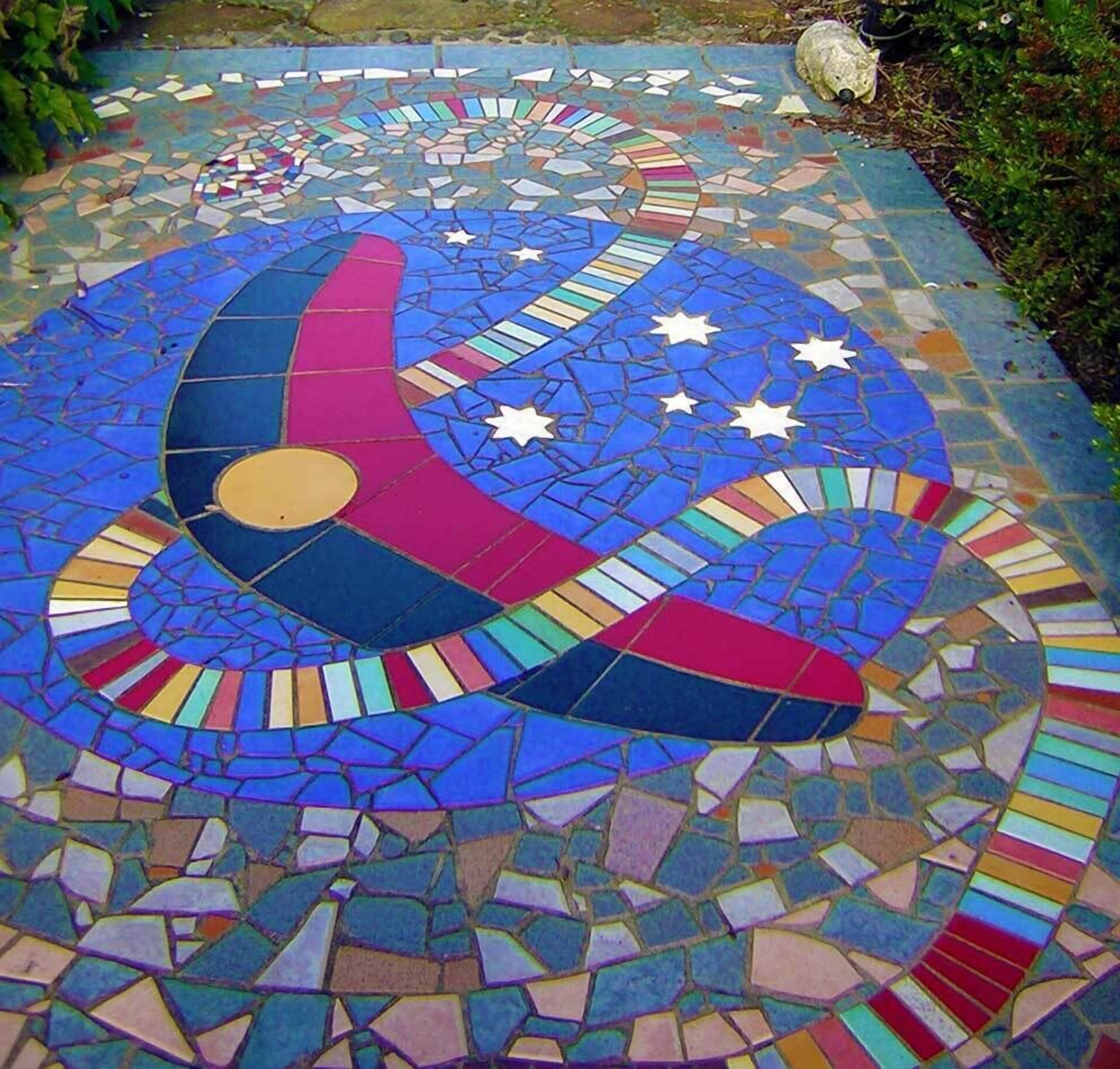 Un suelo de mosaico con un diseño de luna creciente, estrellas y un círculo amarillo.