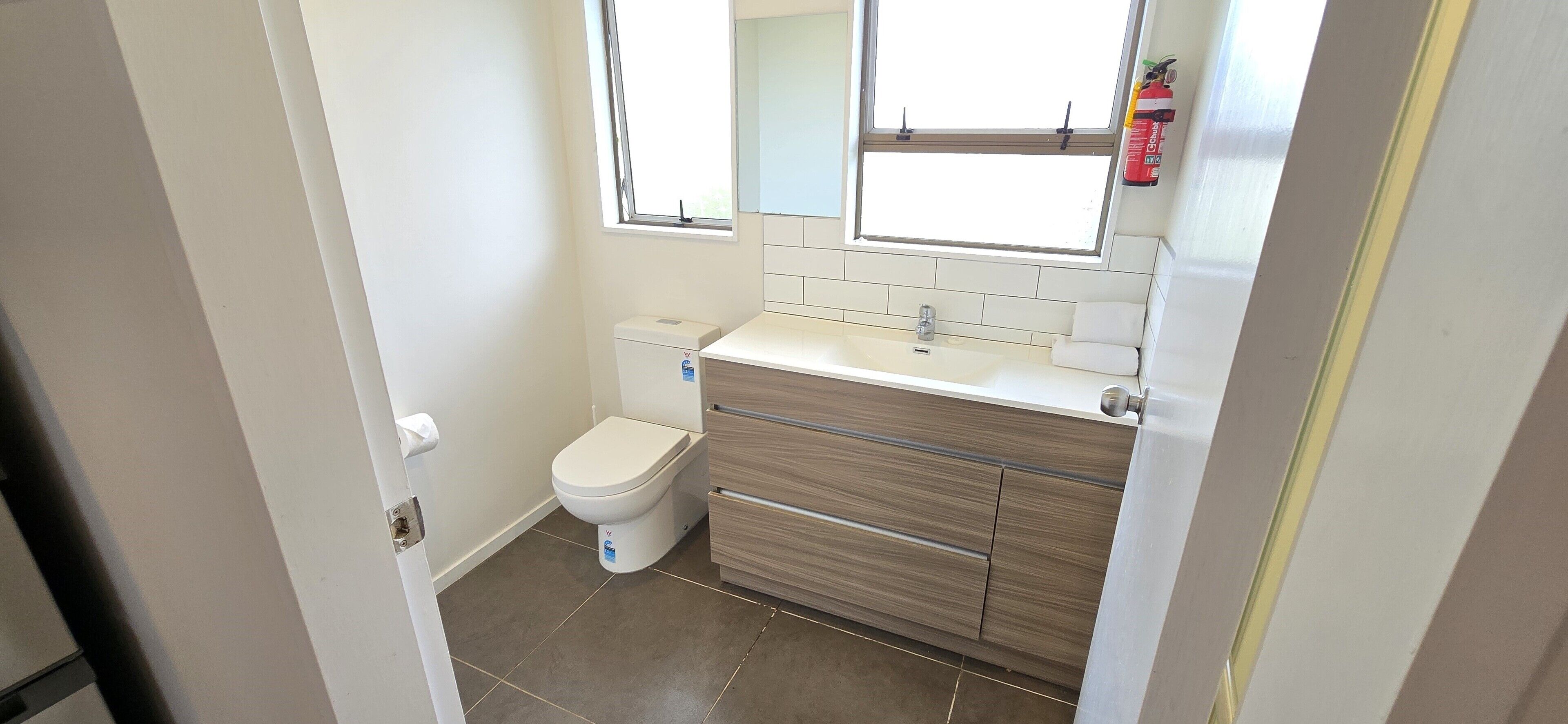 Un baño pequeño con inodoro, lavamanos y espejo.
