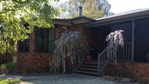 A brick house with a covered porch, a staircase, and a gravel driveway. - Beechworth Gorge Walk Guest House (Beechworth)