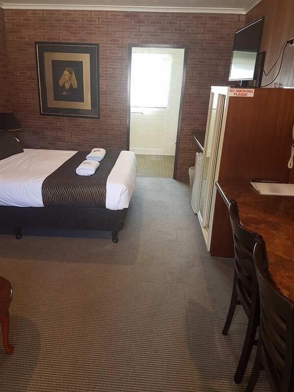 A hotel room with a bed, a desk, a chair, a television, and a "No Smoking" sign. - Bulahdelah Motor Lodge (Bulahdelah)