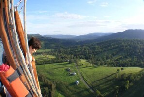 A scenic view from a high vantage point, overlooking a valley with green fields and distant hills.