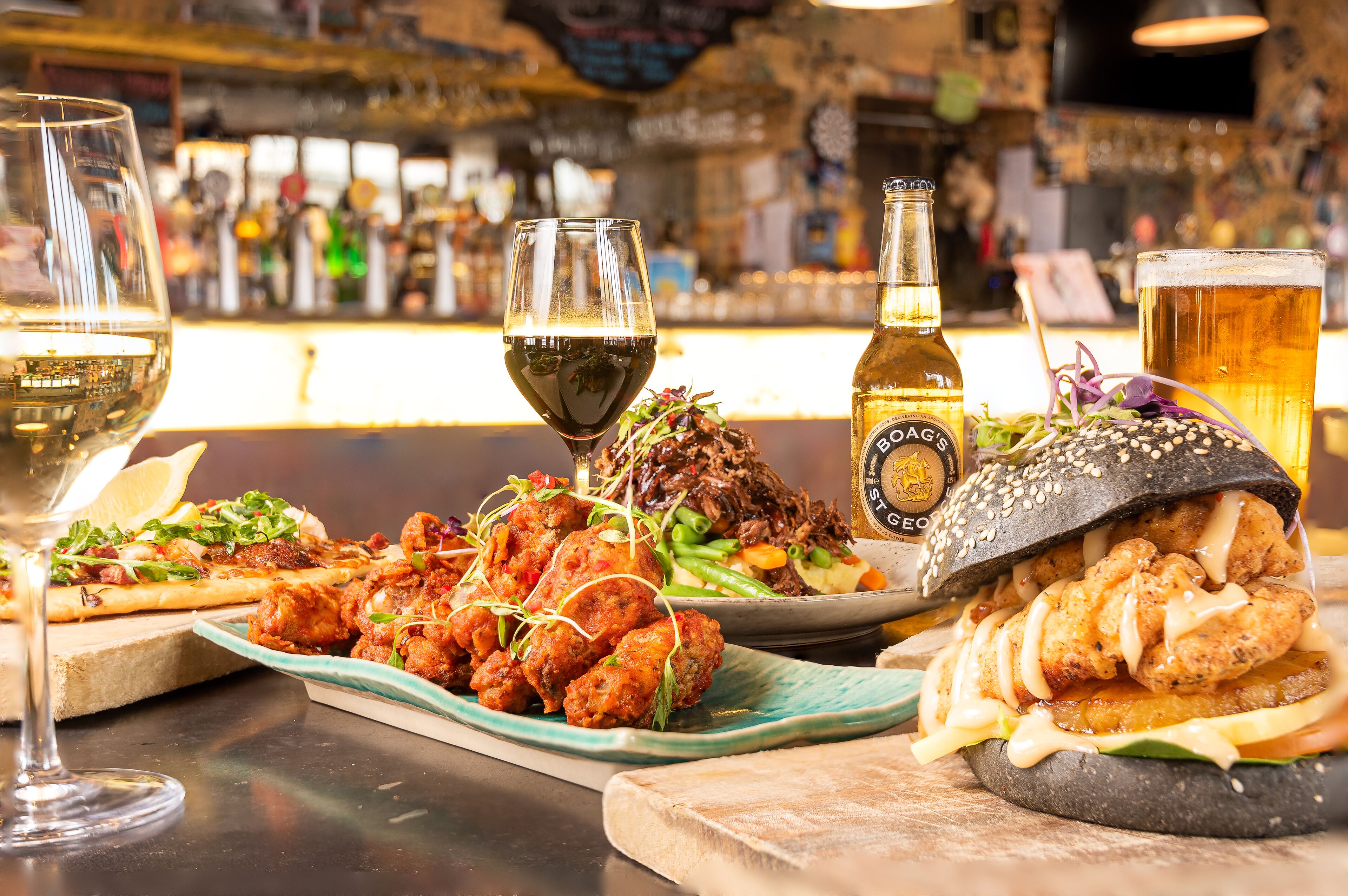 A bar setting with a variety of food items and drinks.