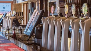 A bar area with multiple beer taps and a digital screen. - Formby Hotel (Devonport)
