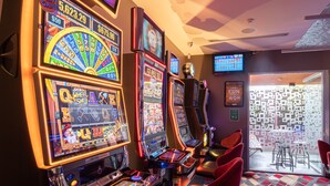 A casino with slot machines, a neon sign, and a view of the outside. - Formby Hotel (Devonport)