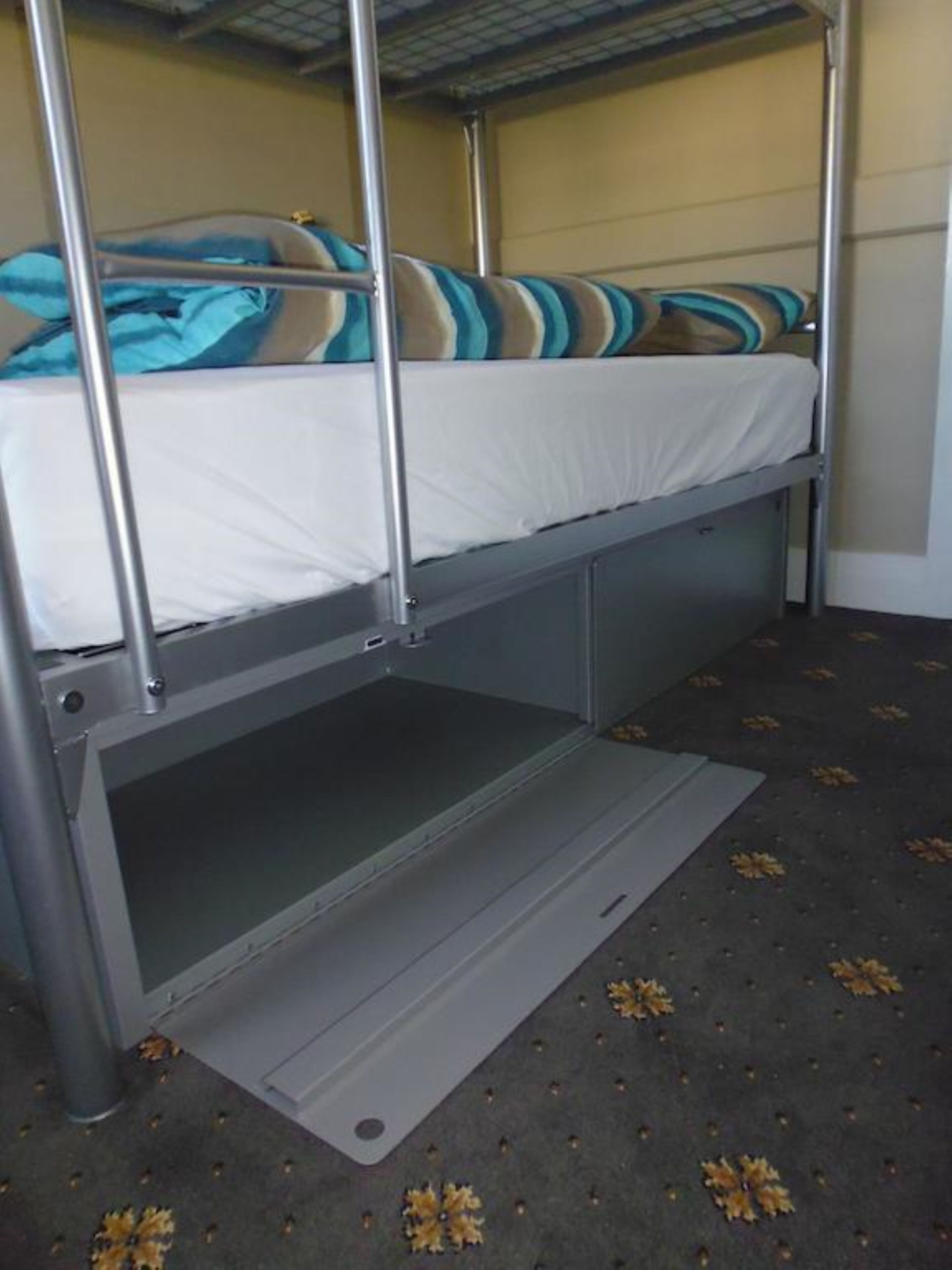 Una cama litera con una cama inferior y un colchón con ropa de cama a rayas.