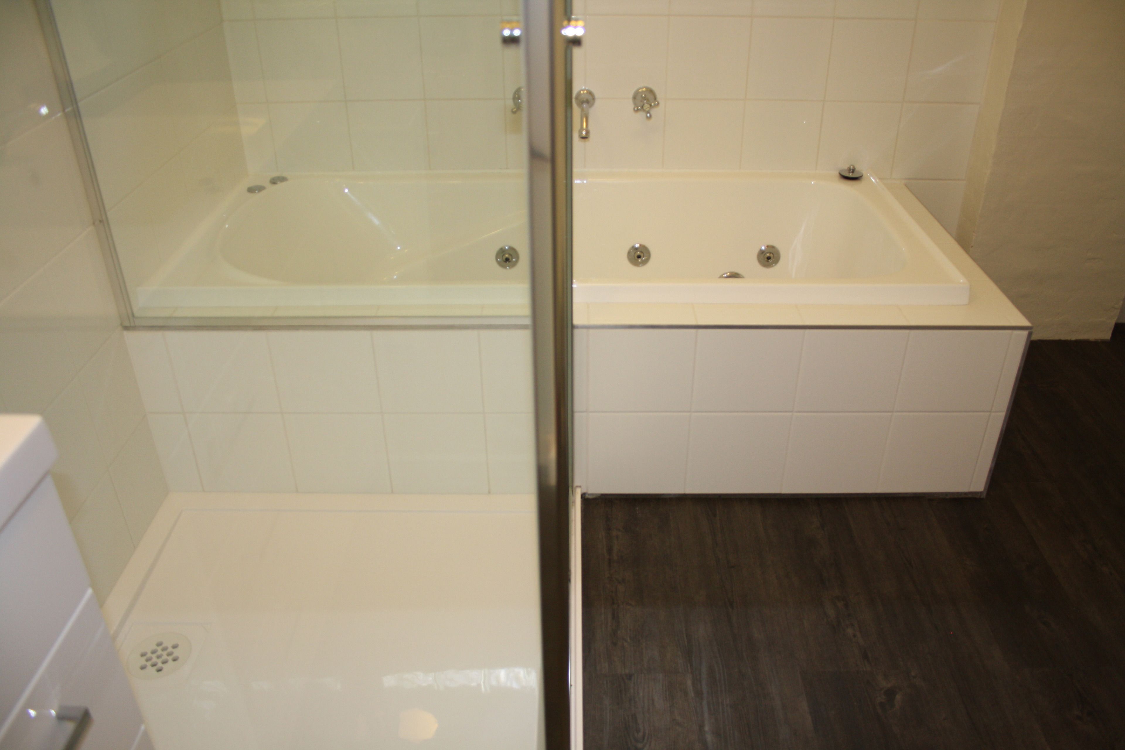 A bathroom with a glass-enclosed shower, a separate bathtub, and a toilet.