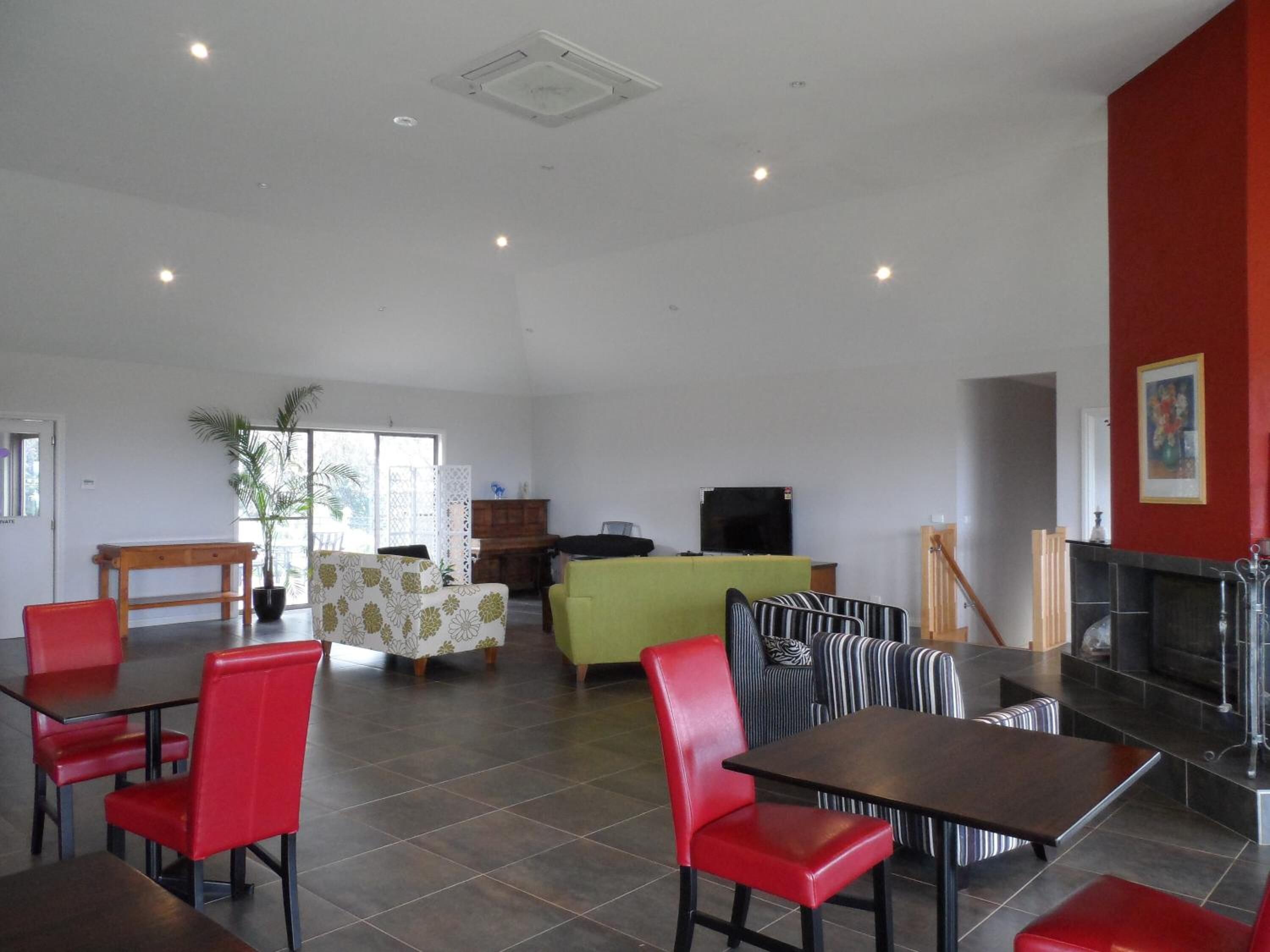A spacious indoor area with a dining area, seating, and a fireplace.
