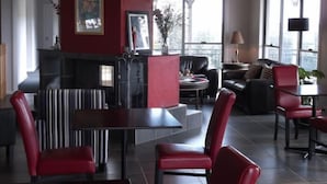 Una sala de estar moderna con chimenea, zona de estar y ventanas amplias.