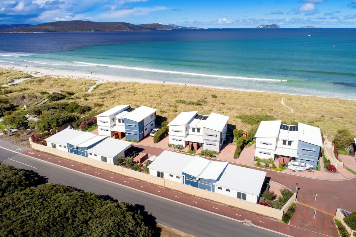 A coastal property with multiple buildings, a road, and a beach.