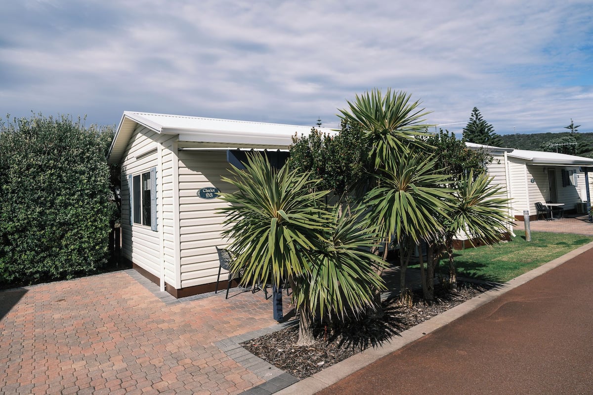 A single-story mobile home with a paved driveway and a well-maintained lawn.