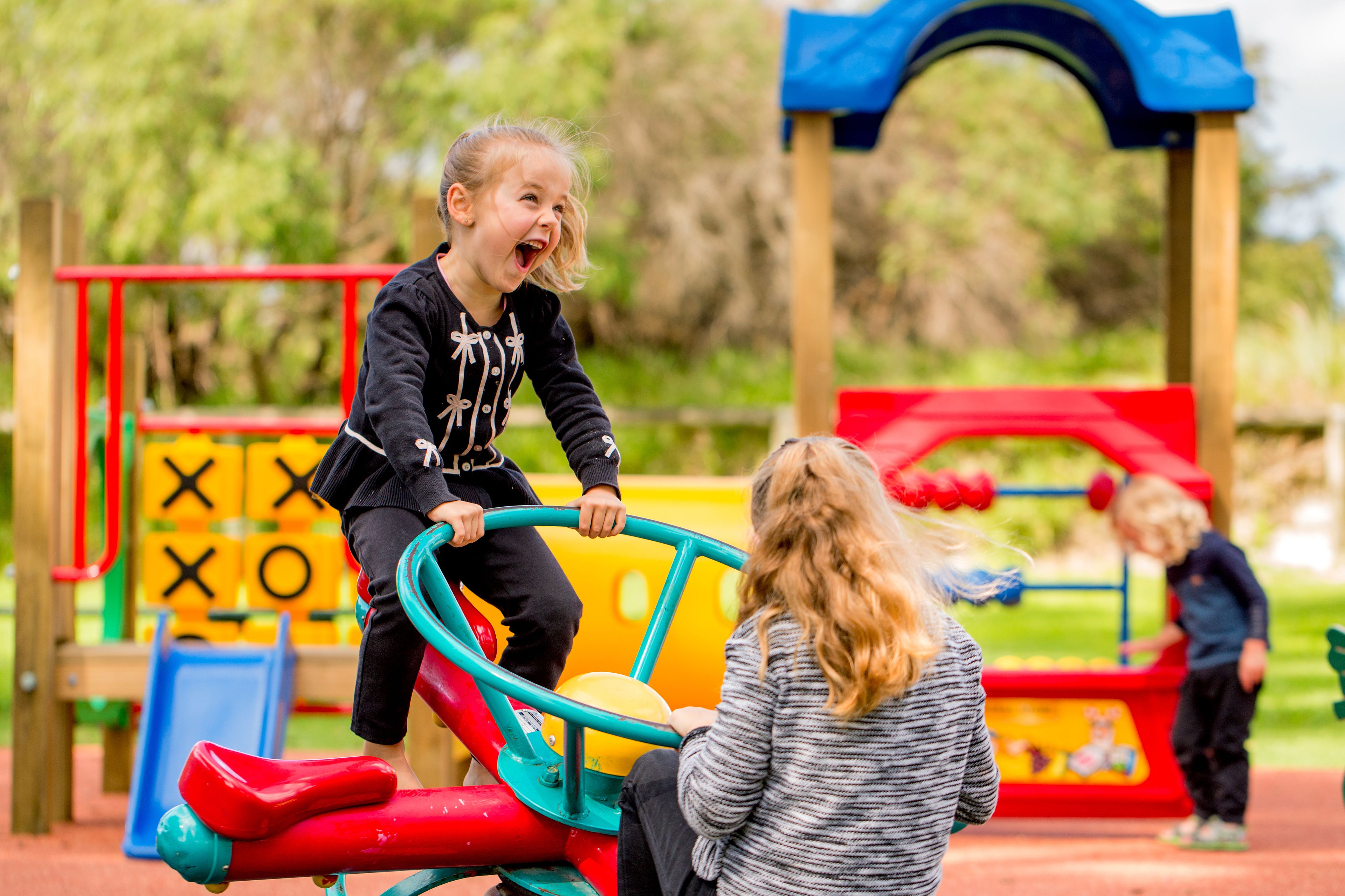 Un parque infantil con un sube y baja y un tobogán.