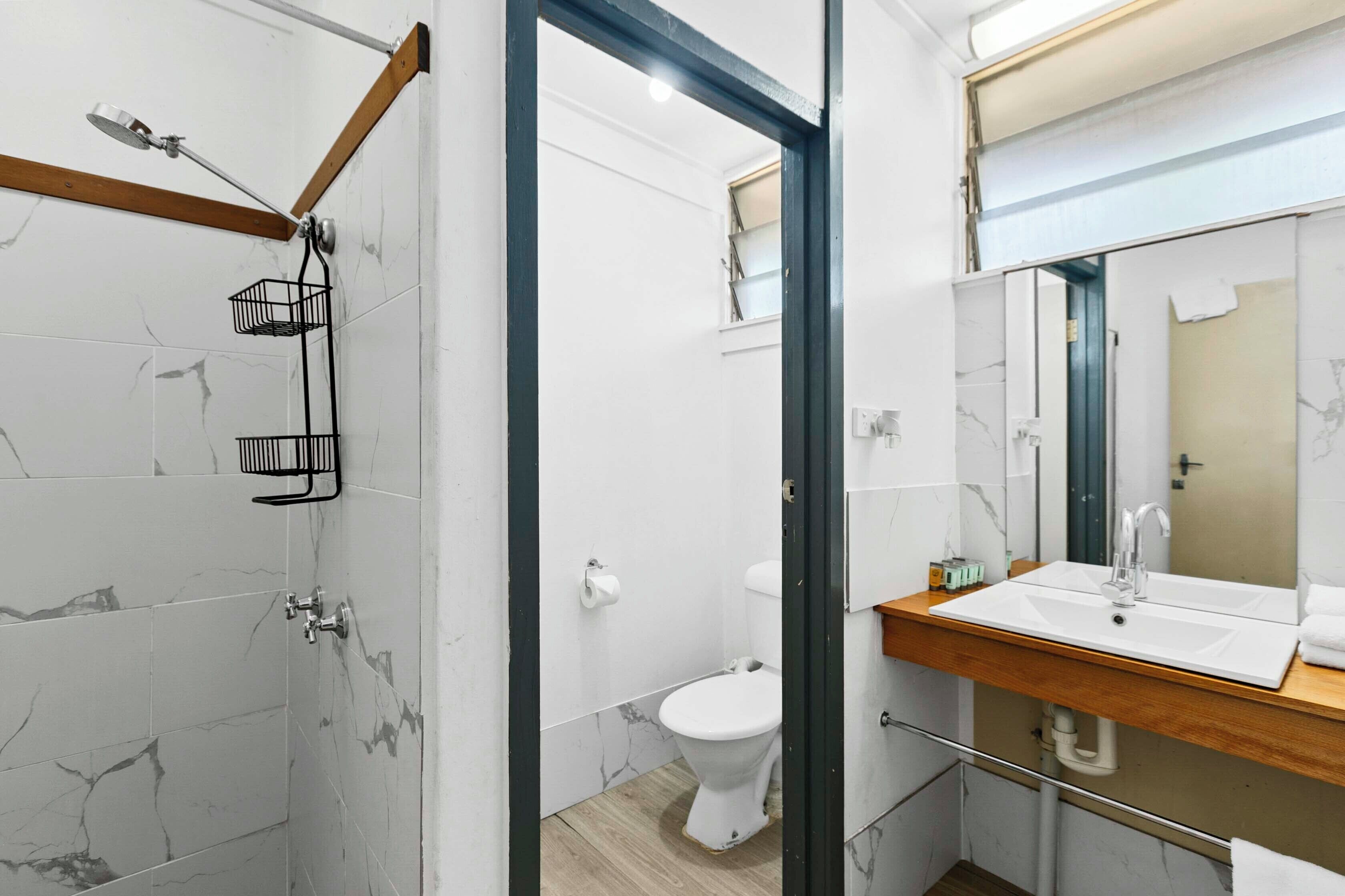 Un baño moderno con ducha, inodoro y lavamanos.