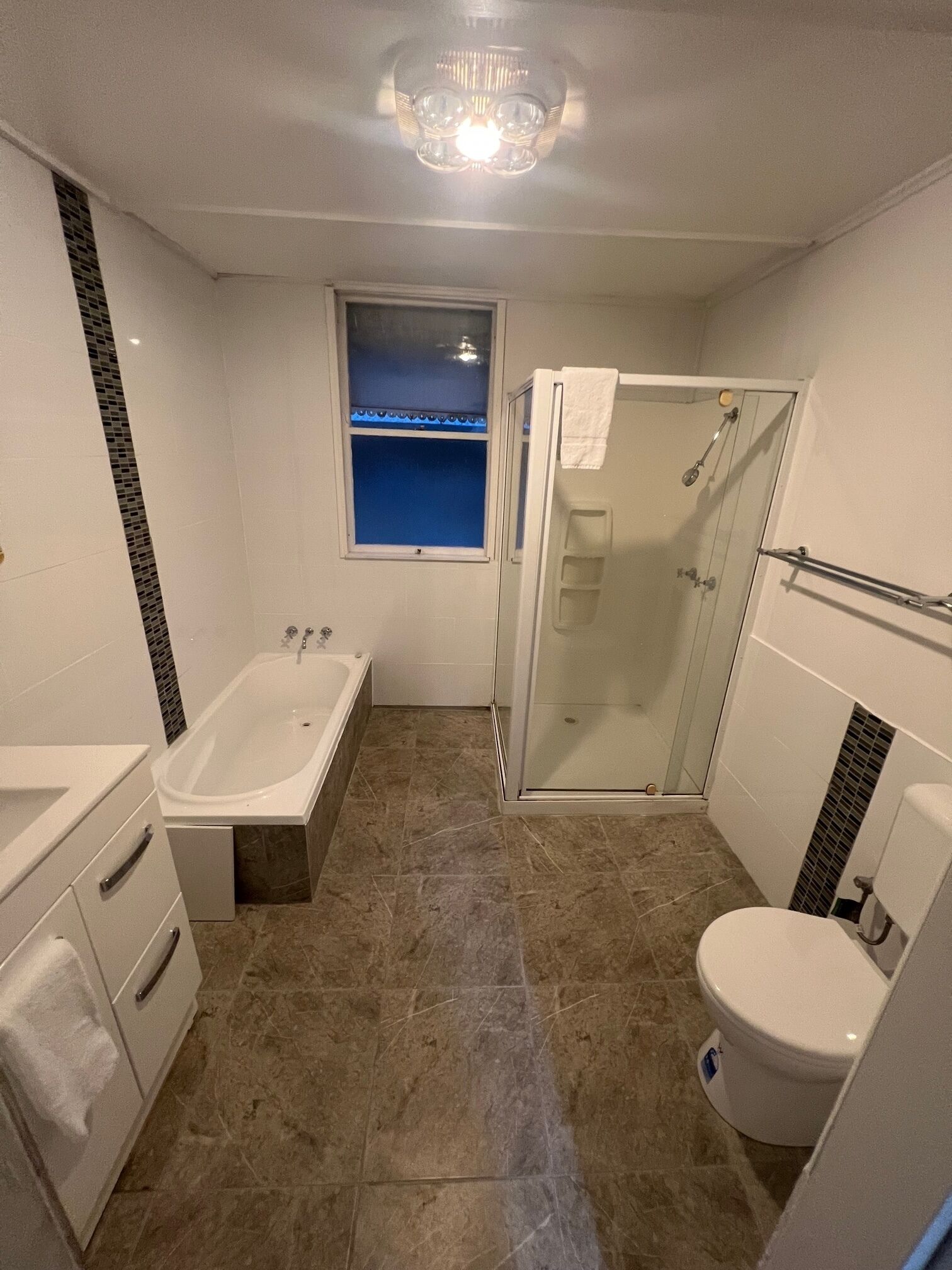 Une salle de bain moderne équipée d’une baignoire, de toilettes et d’un espace douche.