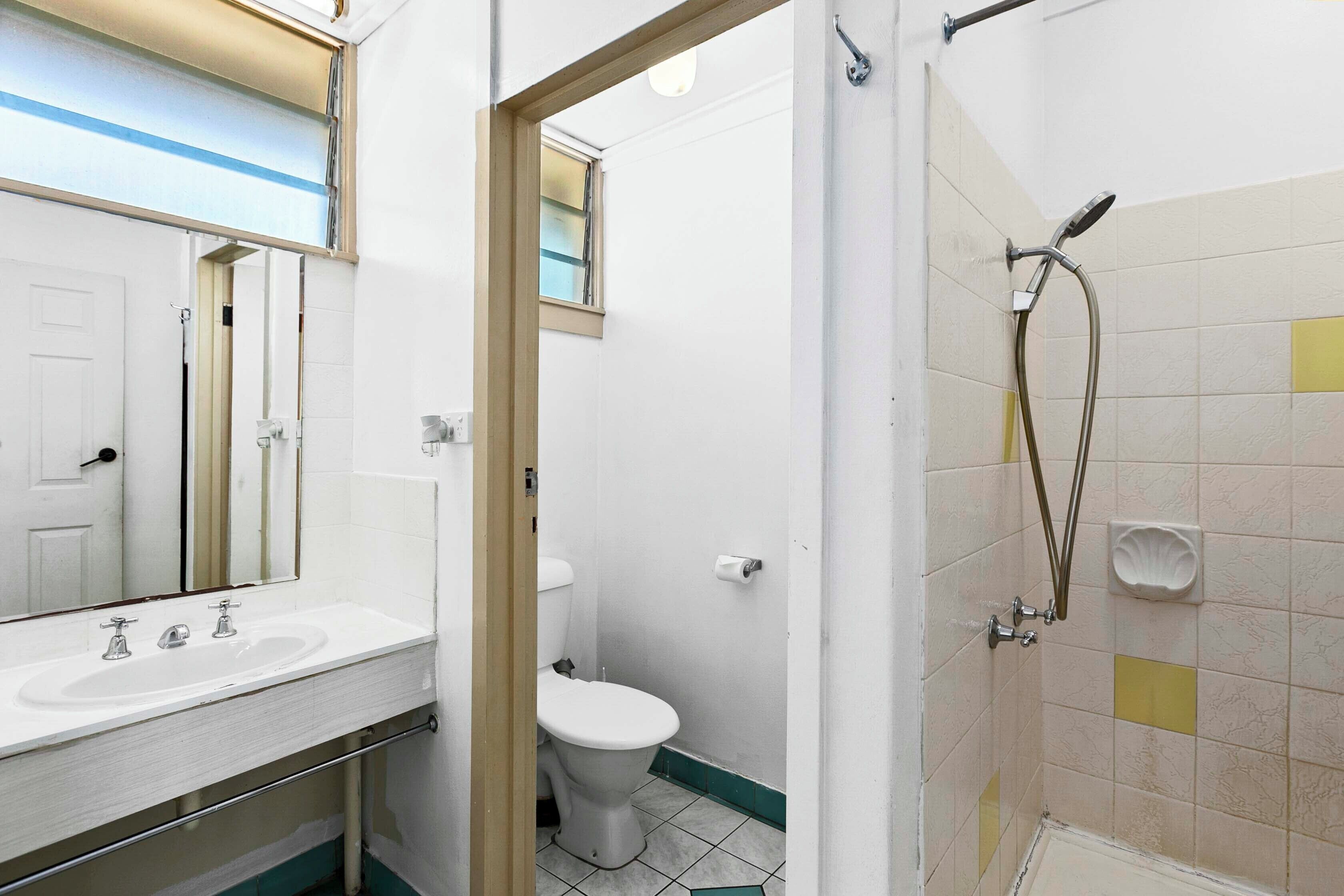 A bathroom with a sink, toilet, and shower.