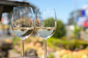 Dos copas de vino vacías sobre una mesa con un fondo desenfocado al aire libre.