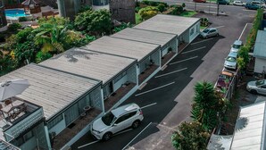 A hotel with a pool, a parking lot, and a view of the sea. - Ala Moana Motel (Paihia)