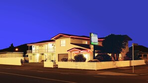 A two-story motel with a fenced front yard, a sign indicating a price of $90, and a 'Vacancy' sign. - Kerry's Motel (Rotorua)