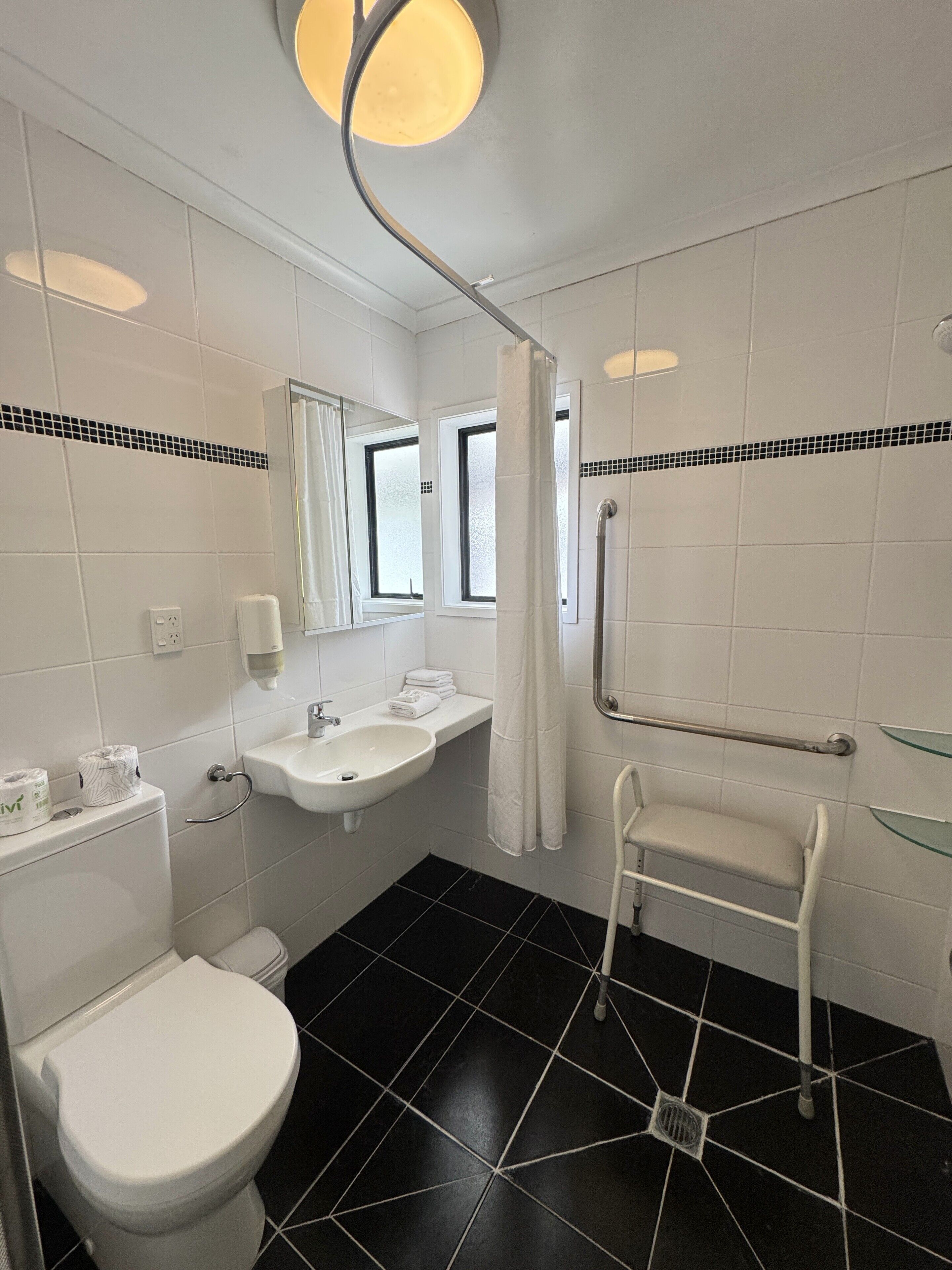Une salle de bain comprenant des toilettes, un lavabo et un espace douche.