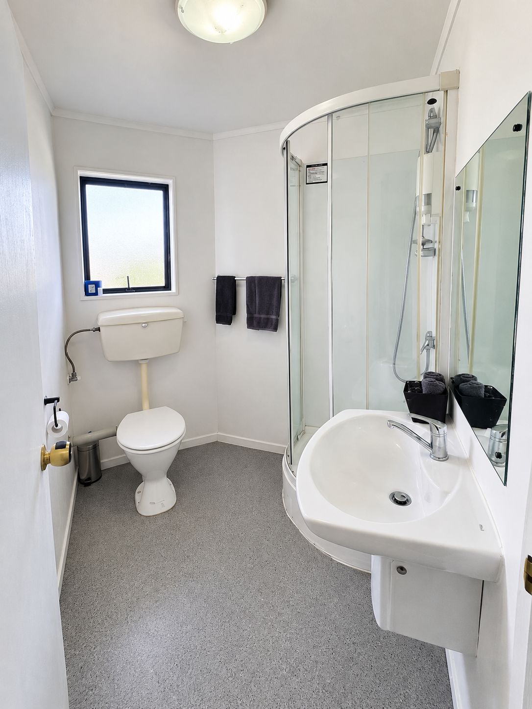 Un baño con inodoro, lavamanos y ducha.