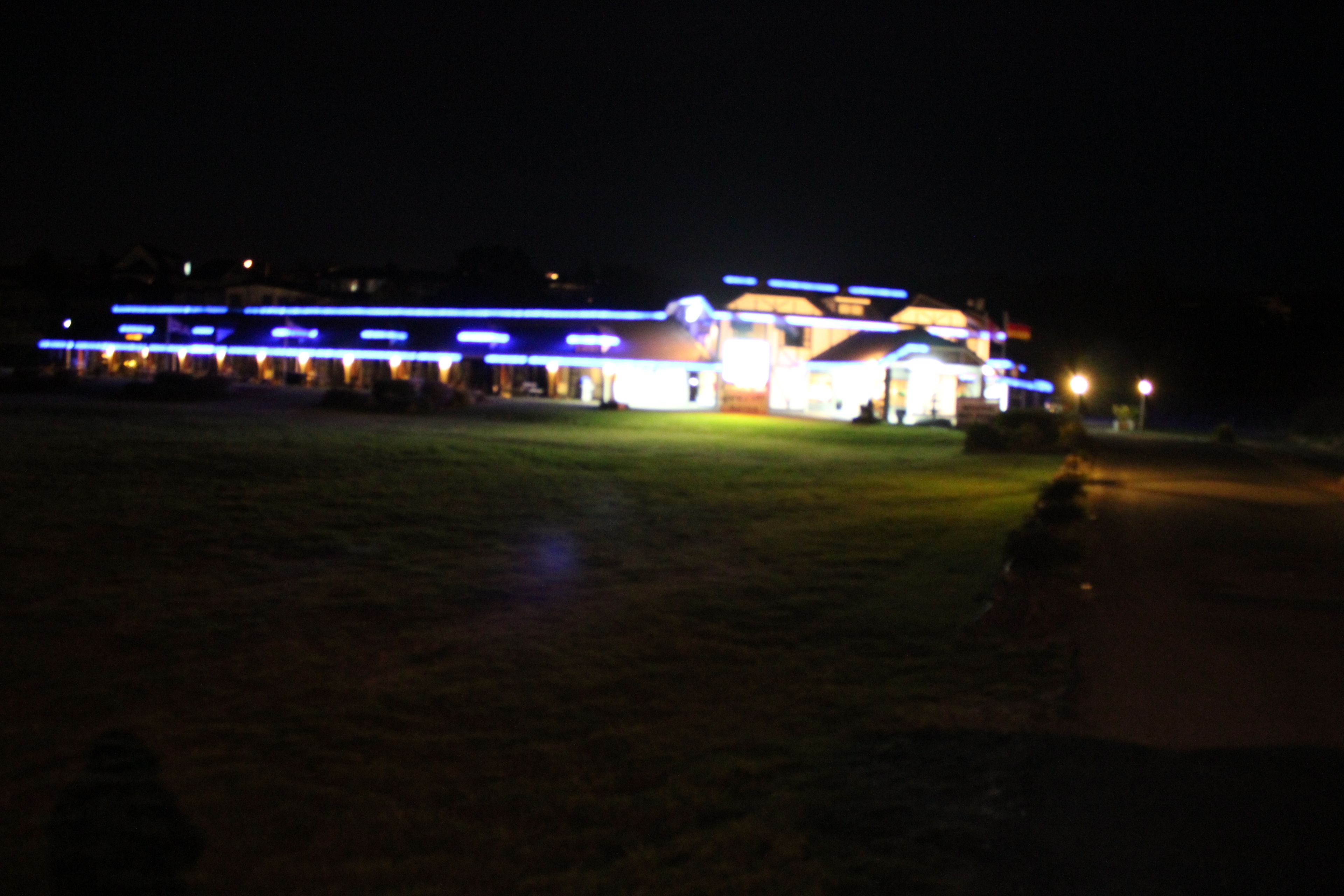 A building with illuminated signage and a large open space in front.