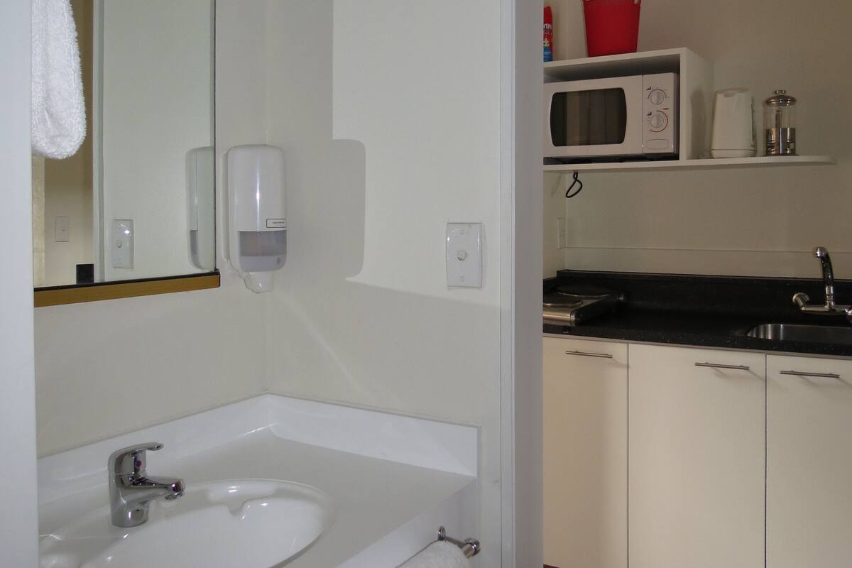 Une salle de bain moderne avec un lavabo blanc, un miroir et un porte-serviettes.