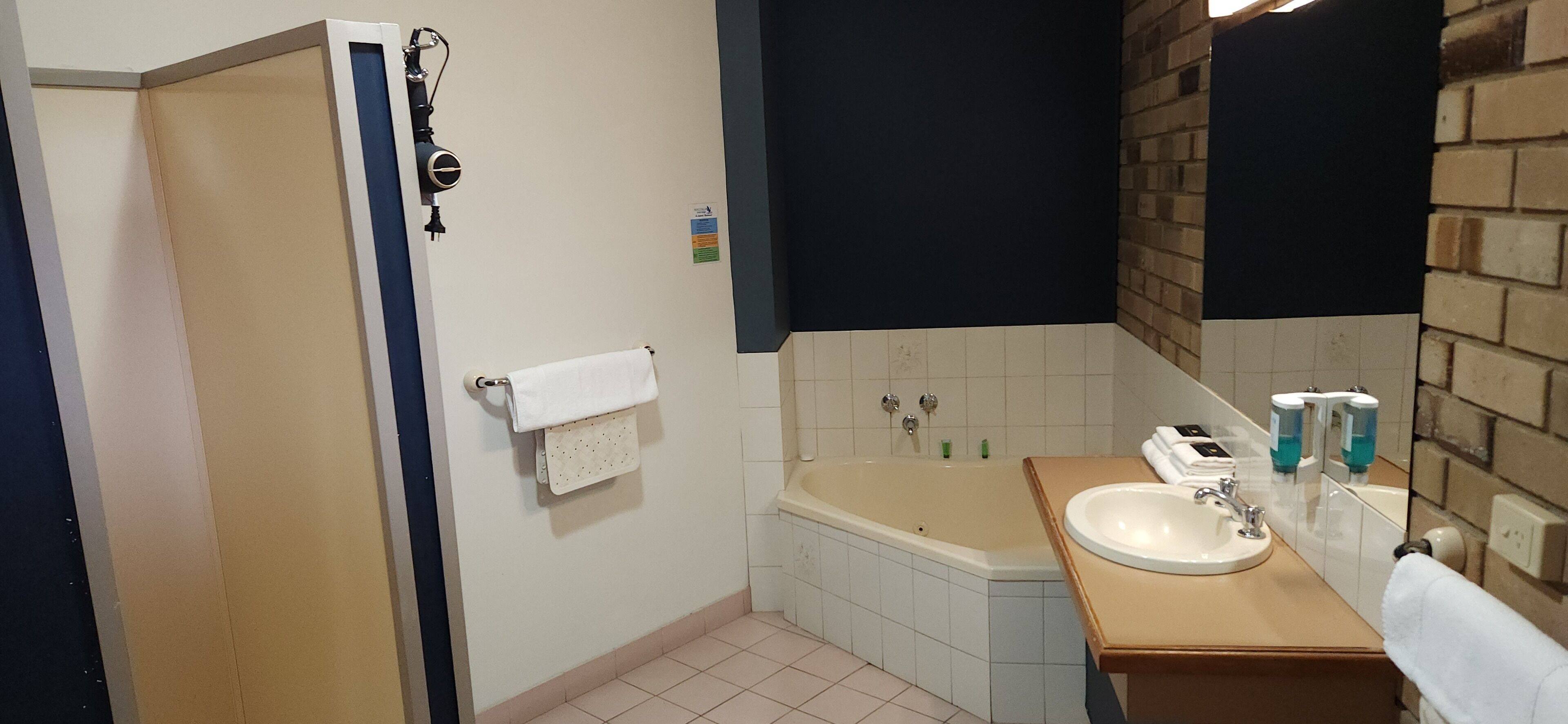 A bathroom with a bathtub, a sink, and a towel rack.