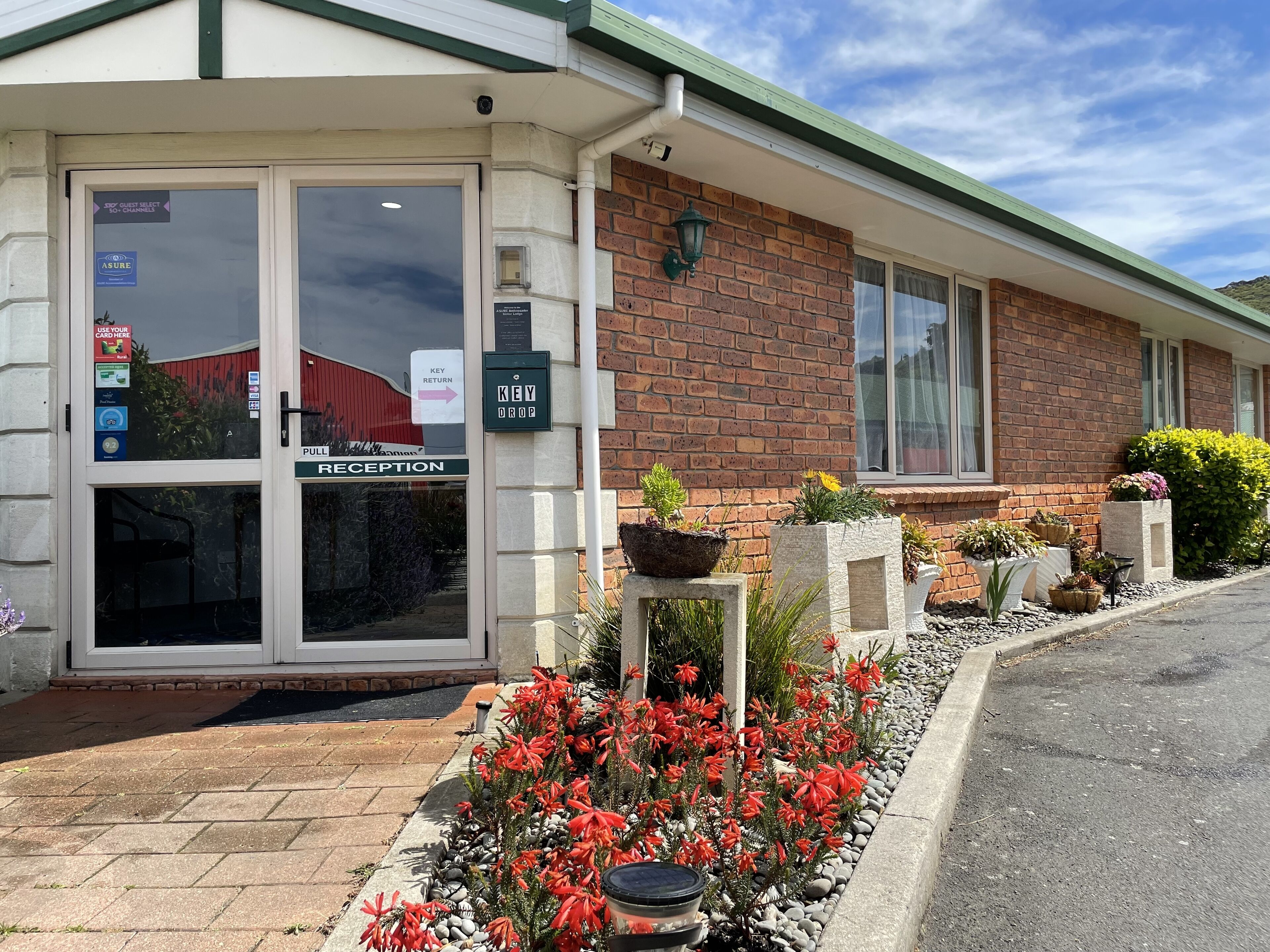 A hotel entrance with a reception area, a key drop, and a sign for ASURE.
