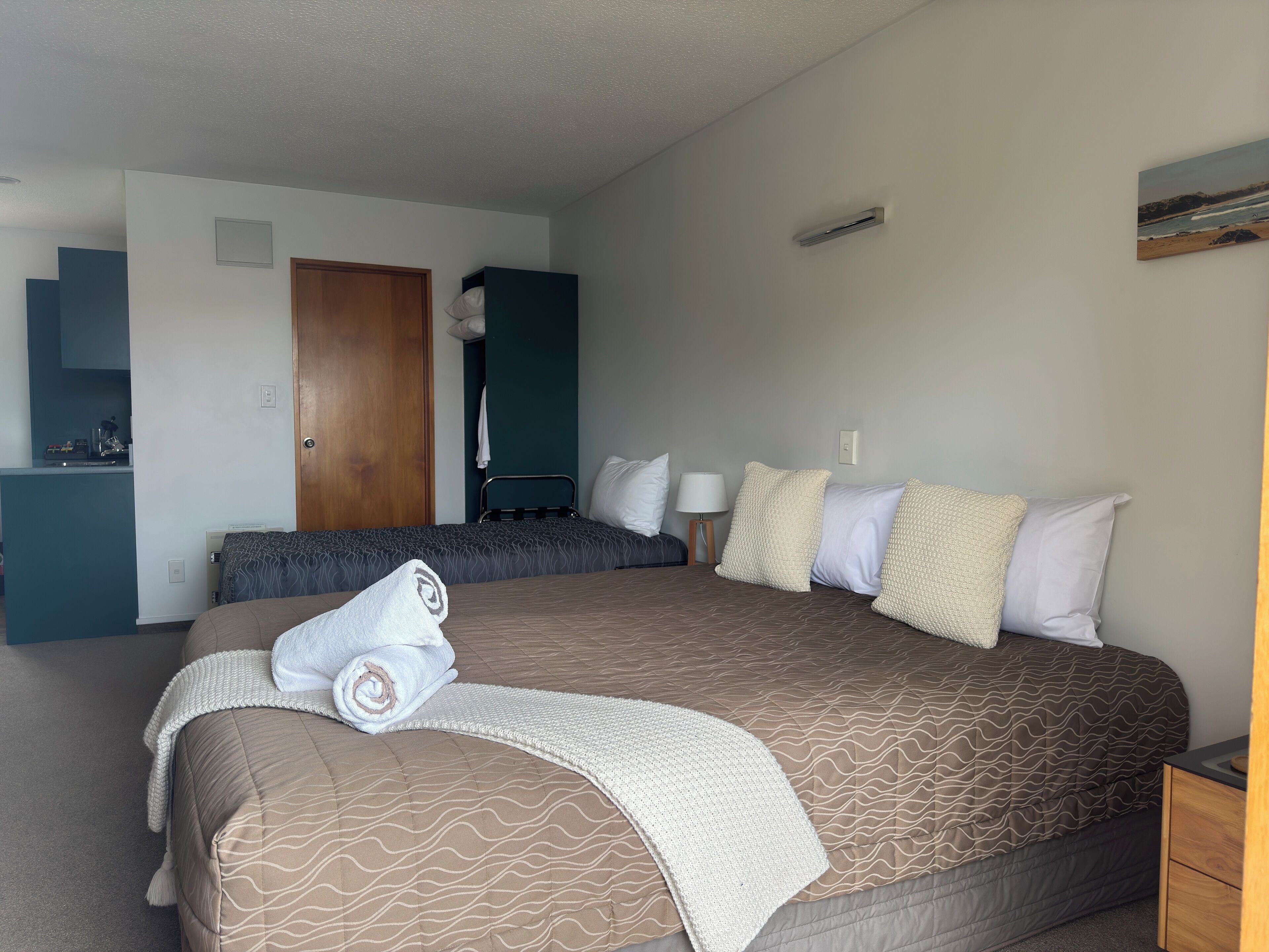 Una habitación de hotel con una cama grande, un escritorio, un armario y un baño.