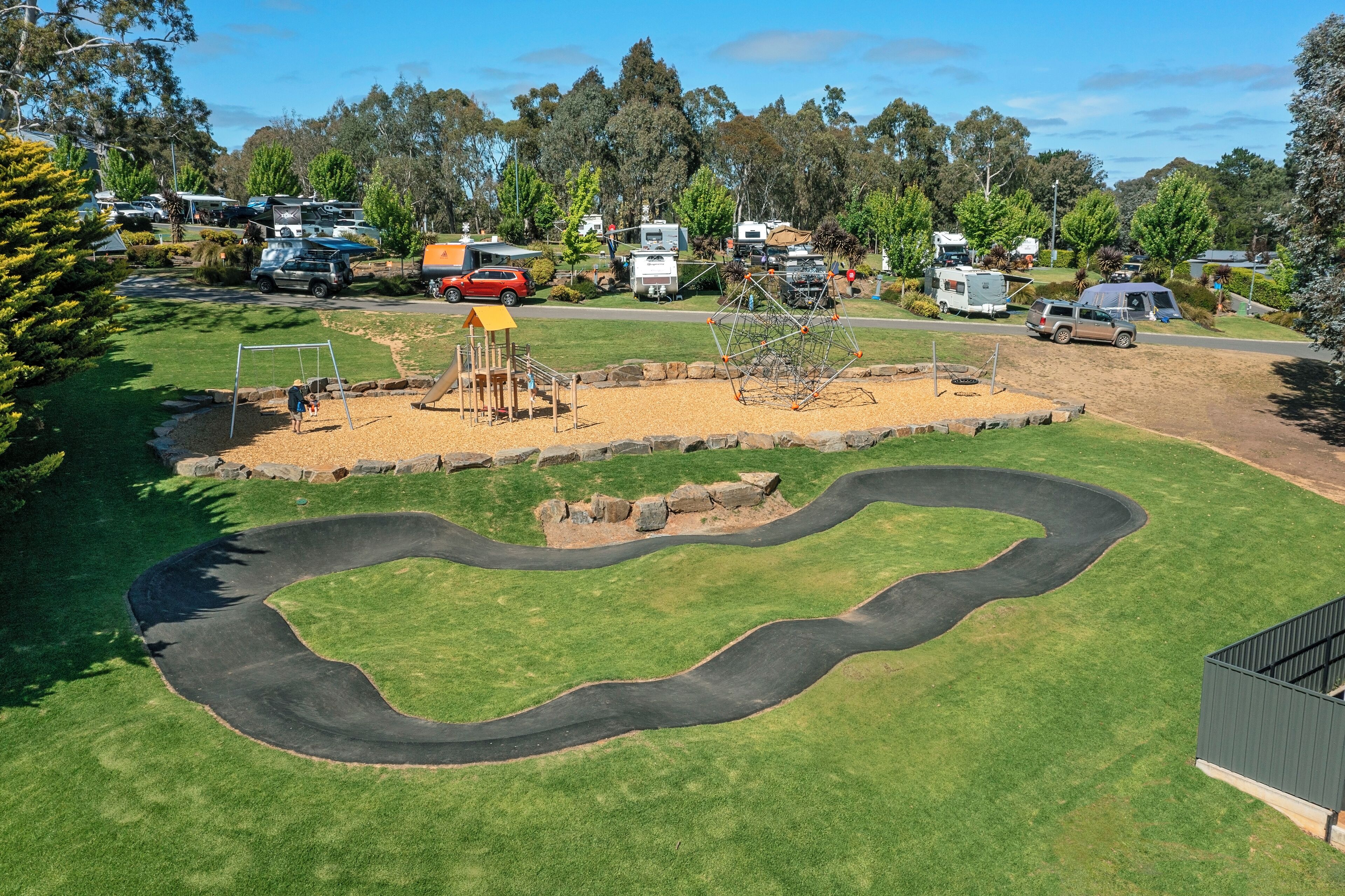 A campground with RVs, a playground, and a winding path.