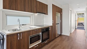 Una cocina moderna con armarios de madera, electrodomésticos de acero inoxidable y un amplio ventanal.