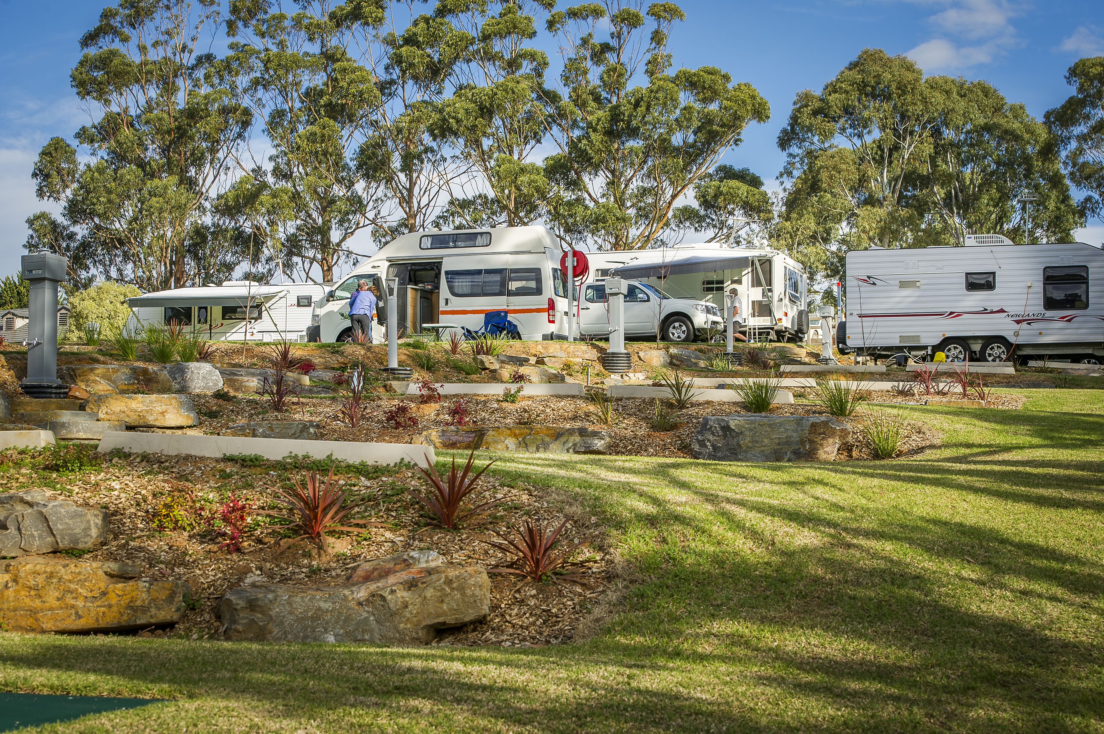 Un terrain de camping équipé d’emplacements pour camping-cars et doté d’un jardin bien entretenu.