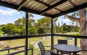 A covered outdoor seating area with a view of a lake and trees. - Discovery Parks - Hahndorf (Hahndorf)
